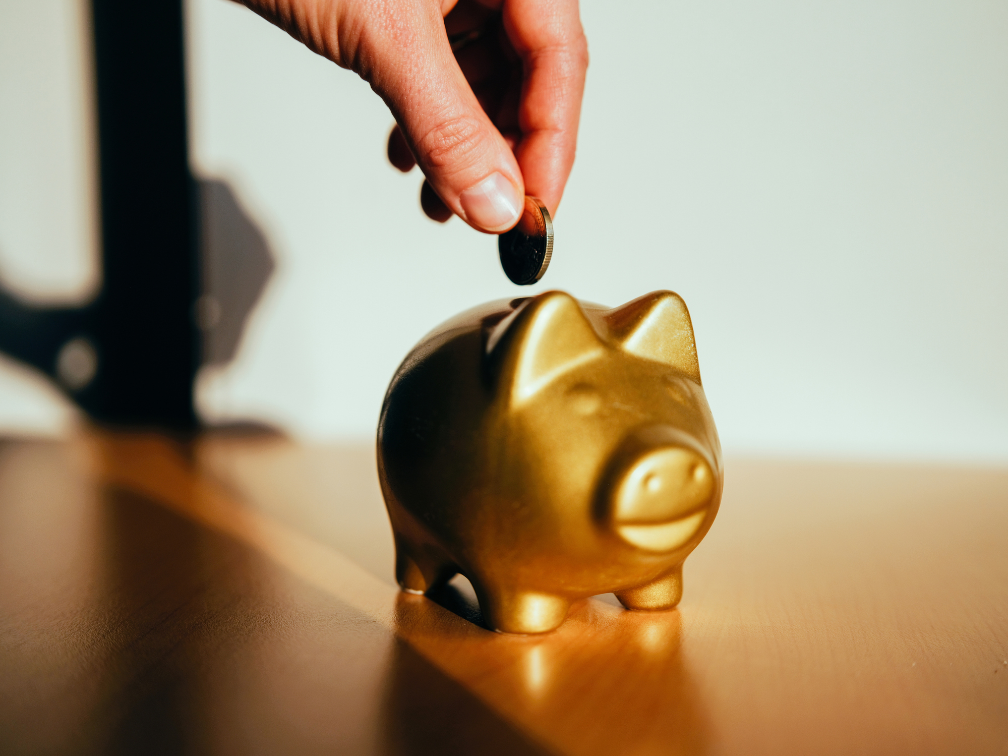 Putting a coin in a golden piggy bank