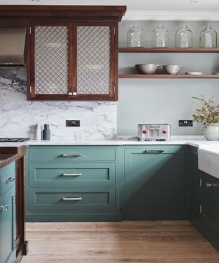 Green kitchen cabinets with marble countertops