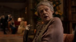 Dame Maggie Smith looks over her shoulder in conversation in Downton Abbey: The Motion Picture.