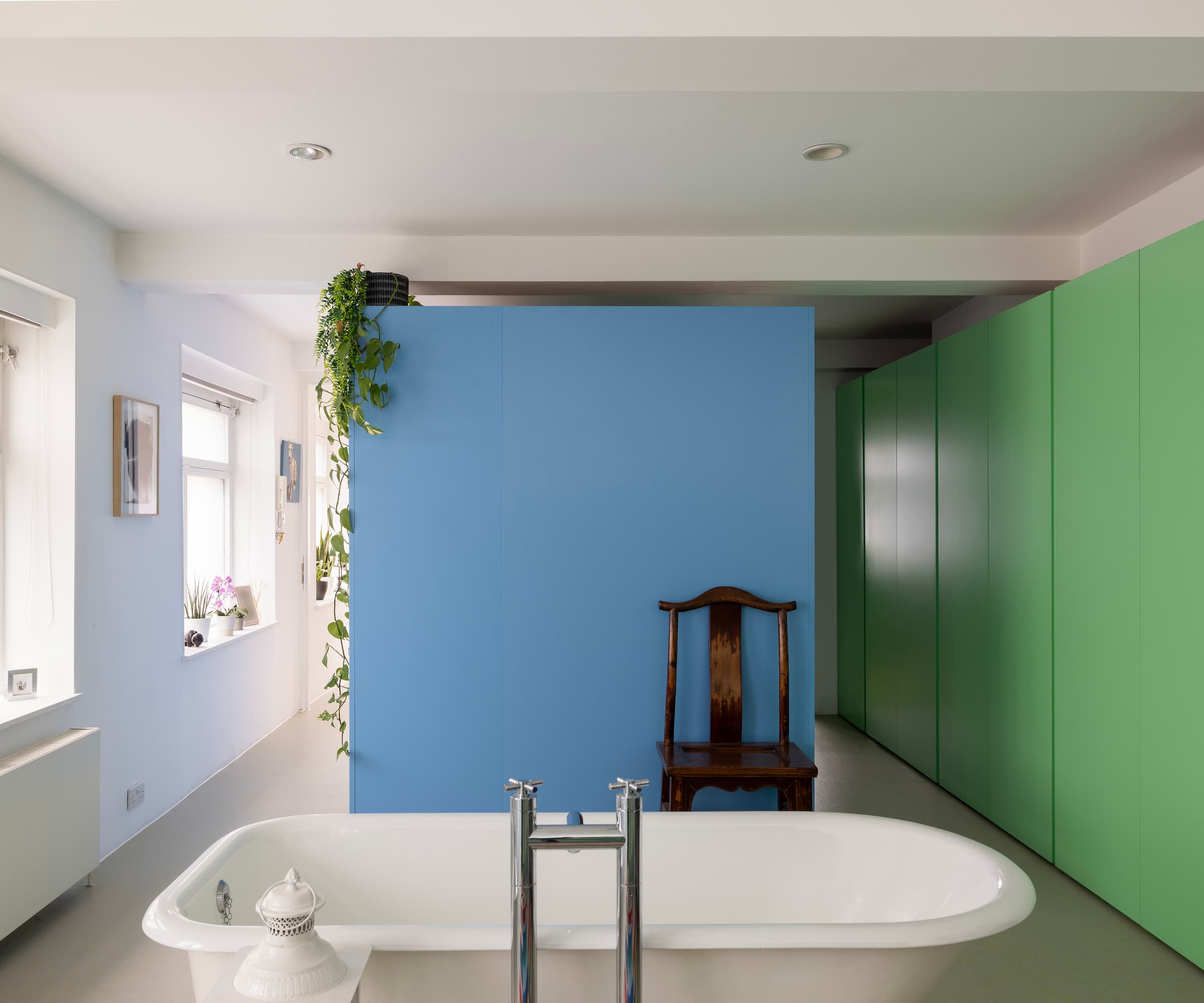 A bathroom with a blue dividing wall and green wall