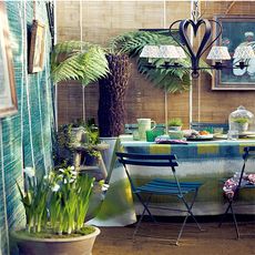 outdoor dining area with ikat tablecloth and rattan walls