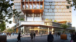 The Centre Monnaie in Brussels. The building is photographed from the front. The front part of the building is lower than the back part, which is covered with floor-to-ceiling windows. The central part looks like a protruding veranda supported by concrete columns.