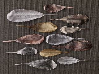 Copper and gold plated leaves displayed on grey cloth