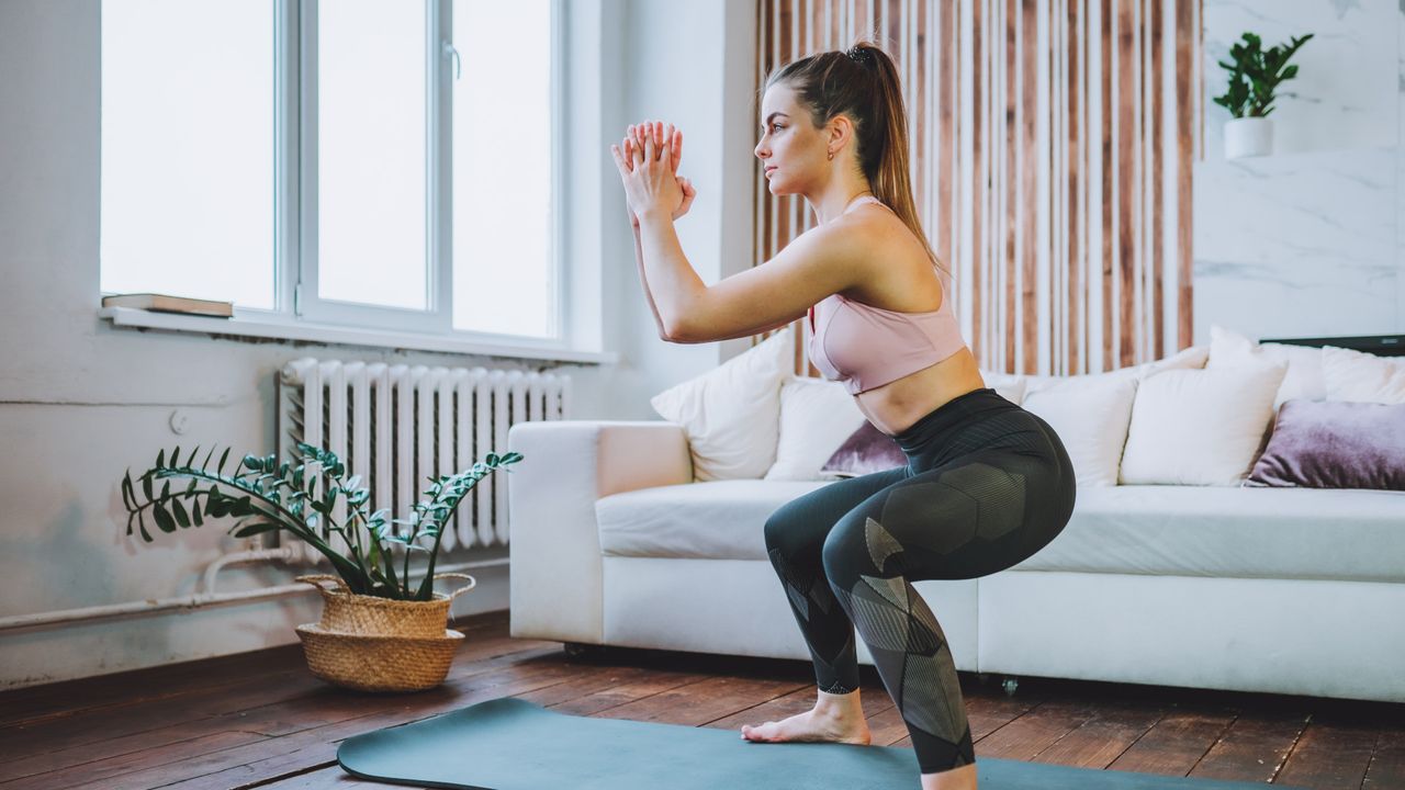 A woman performing a bodyweight squat 