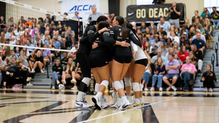Wake Forest women's volleyballers celebrate a point at the net.