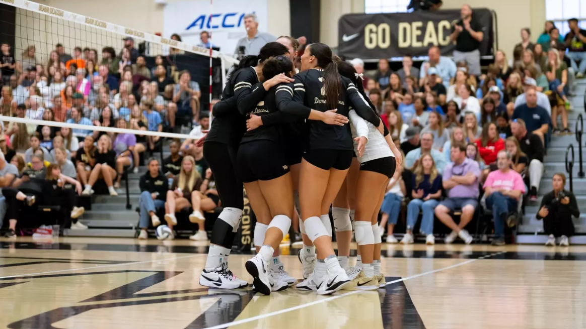 Wake Forest women&#039;s volleyballers celebrate a point at the net. 