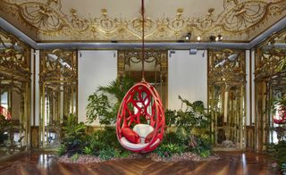 The collection is arranged amongst the plush interiors of Milan's Palazzo Bocconi. The building's marble and marquetry floors are interspersed with lush green foliage, which further serves to highlight the collection's unique design pieces, such as the Campana Brothers' 'Cocoon' seat hanging here.