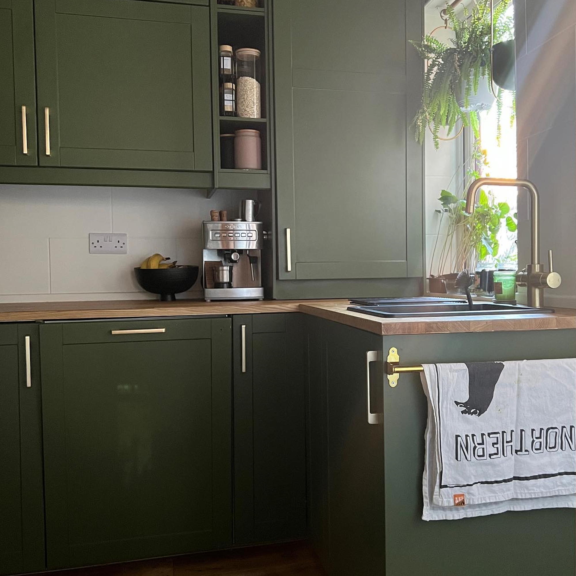green kitchen cabinets with gold tap and handles