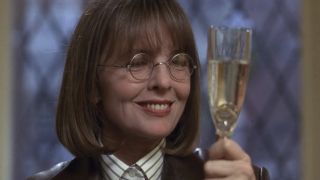 Annie smiling at a champagne flute in The First Wives Club