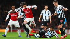 Arsenal midfielder Mesut Ozil takes on Newcastle’s Mohamed Diame, Deandre Yedlin and Florian Lejeune