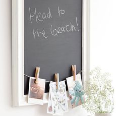 white wall with black board on wall with notes and thread