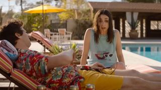 Andy Samberg as Nyles and Cristin Milioti as Sarah Wilder sitting by a pool during one of the best movies on Hulu, Palm Springs.