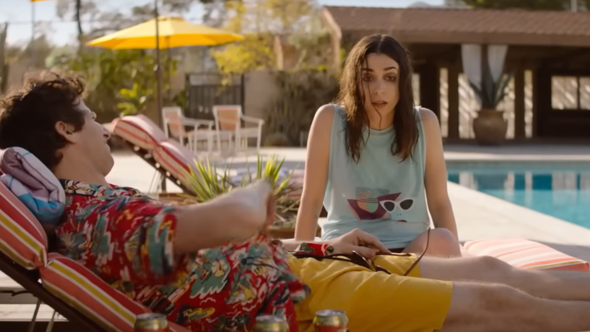 Andy Samberg jako Nyles i Cristin Milioti jako Sarah Wilder siedzący przy basenie podczas jednego z najlepszych filmów w Hulu, Palm Springs.