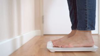 Someone's feet standing on scales, barefoot