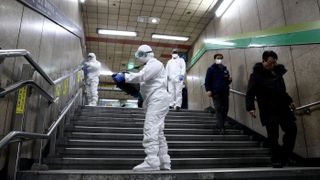 Workers wearing protective gear spray anti-septic solution at a subway station in Seoul, South Korea, on Feb. 21, 2020, as a measure to contain the new coronavirus.