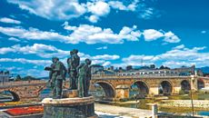 A statue next to a stone bridge