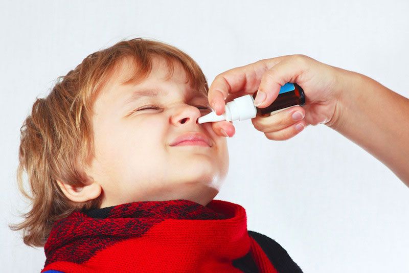 A child receiving a nasal spray