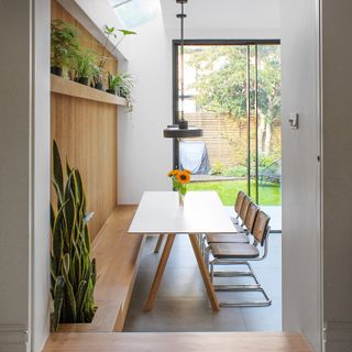 kitchen table with wooden bench seating next to patio doors to the garden