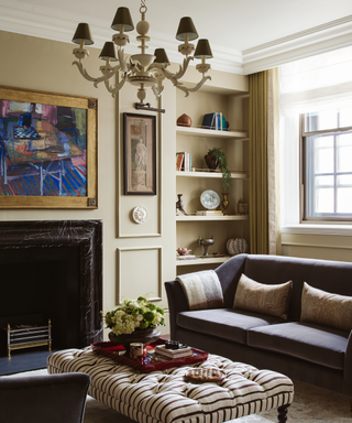 dining room with inbuilt bookshelf, sofa, ottoman, fireplace and artwork