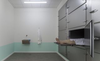 A morgue featuring a dead figure in wax