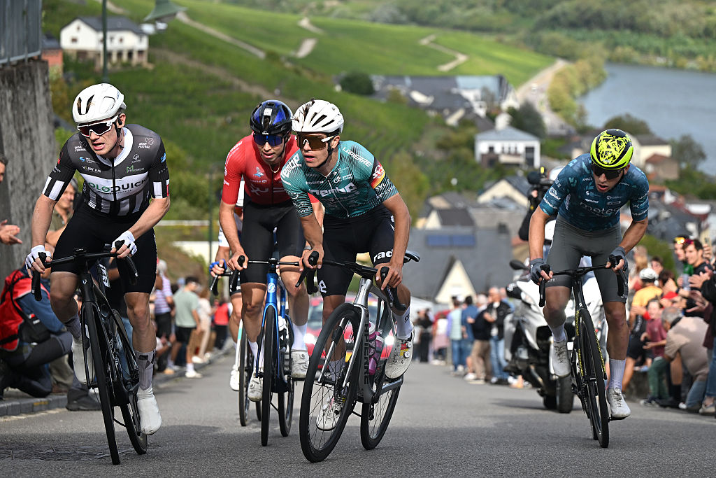 The breakaway riders out of the saddle on a steep climb