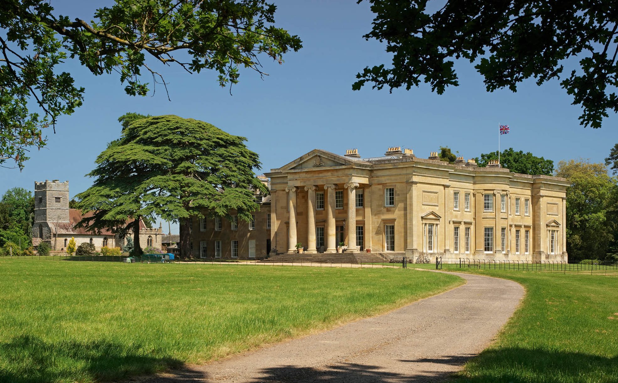 Fig 1: The Ionic portico and bow of Spetchley Park face the original approach. The parish-church tower rises beyond the house. Spetchley Park, Worcestershire. ©Paul Highnam for Country Life