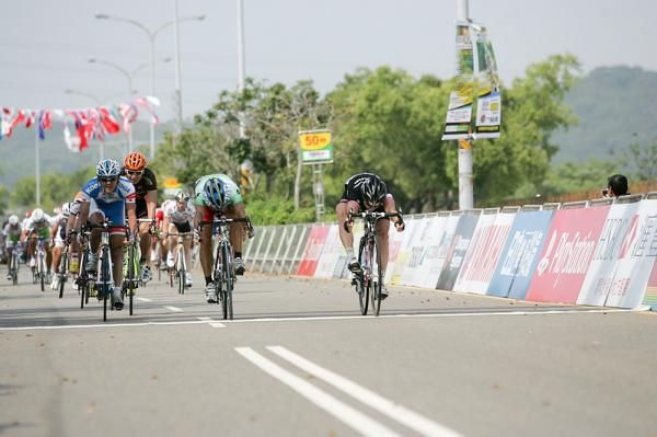 Dean Downing (Rapha Condor) takes the win with a bike throw.