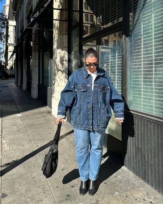 Spring Outfits: Javi wears a double denim outfit with boots and shoulder bag.