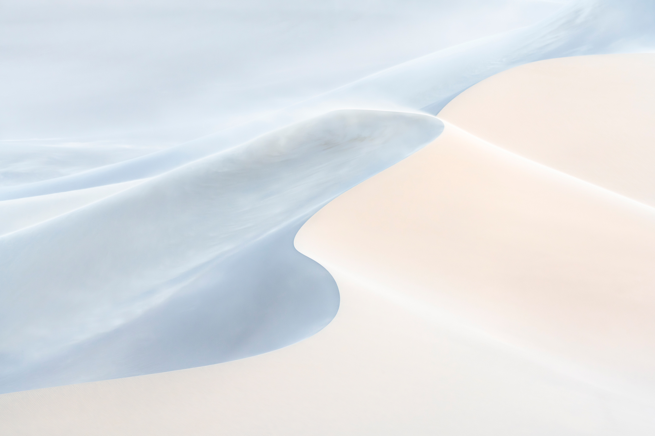 A serene abstract landscape featuring soft curves of light blue and pale sand, creating a tranquil and harmonious composition
