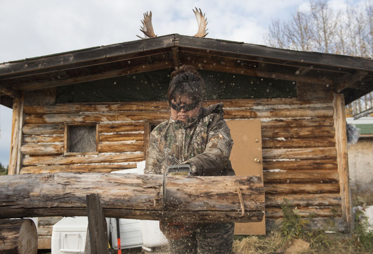 Anita Chicot cuts firewood for the Tathlina Lake camp.