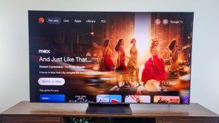 A TCL QM8K QD-Mini LED TV on a TV stand.