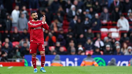 A telephoto shot of Mohamed Salah of Liverpool FC acknowledging fans during a Premier League match, with the Wasabi logo visible behind him.