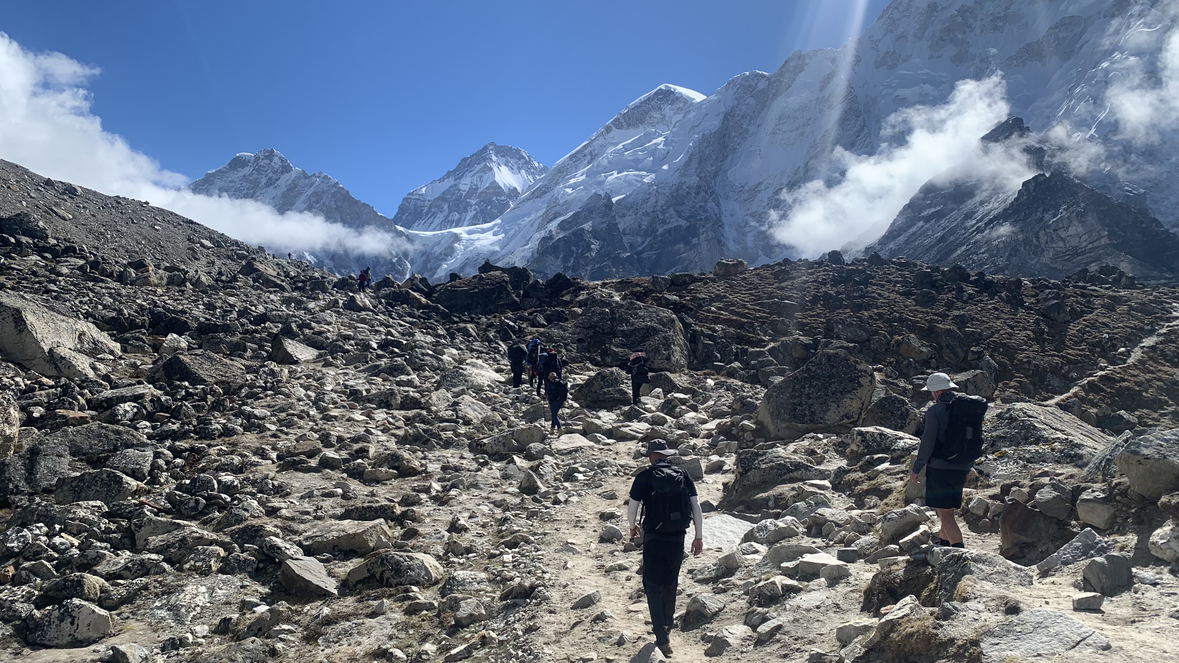 Men trekking through a boulder field on the way to Everest Base Camp