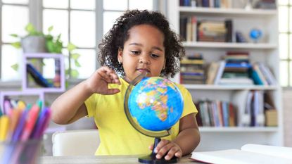 Little girl pointing at globe