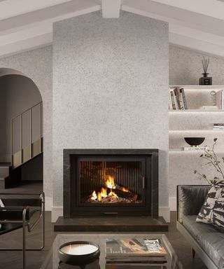 white cork wall clad fireplace, alcove and archway in modern living room with large black fireplace, grey leather sofa and coffee table