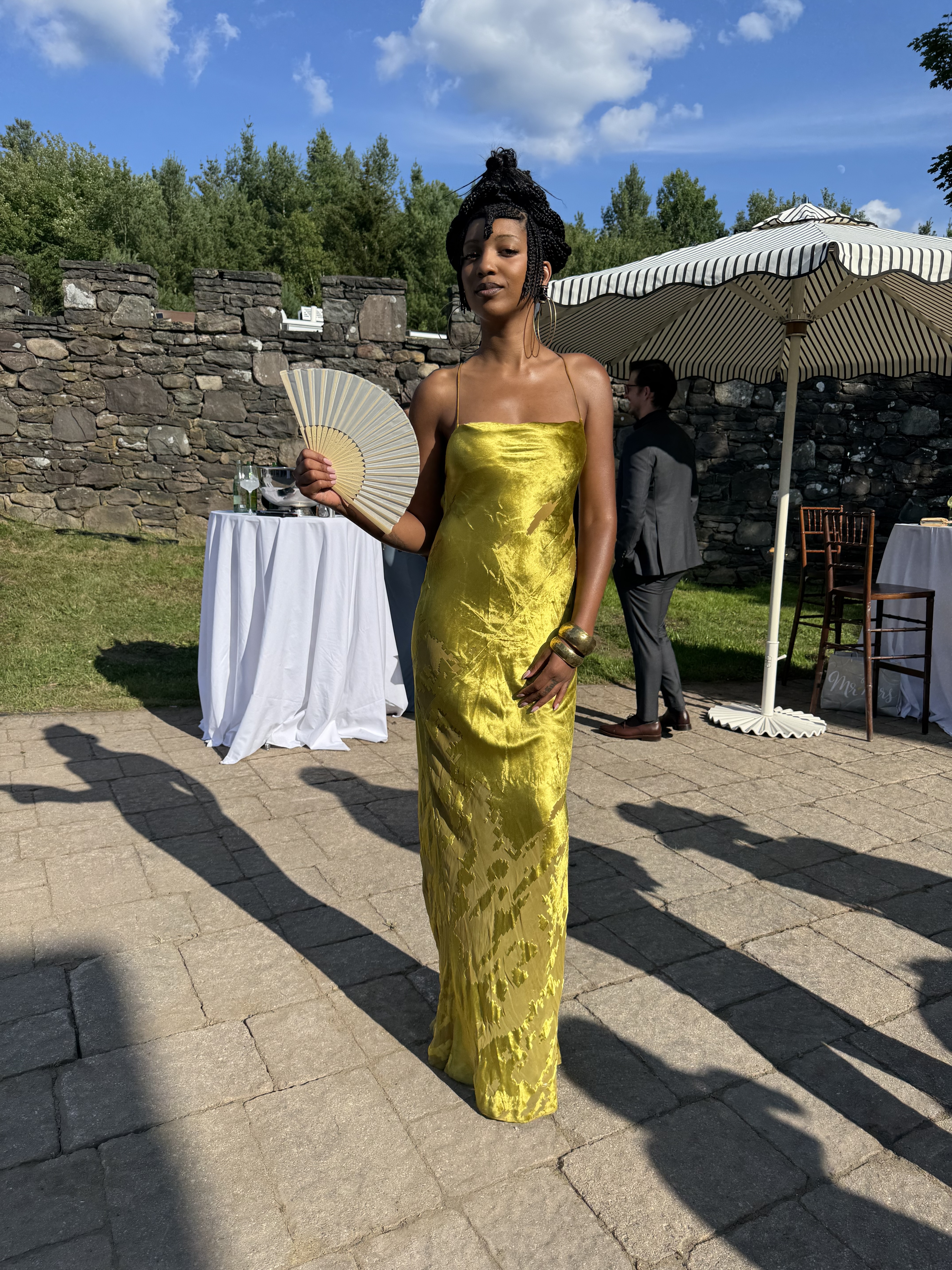 a woman wearing a dark yellow wedding guest dress at a wedding, photo from Mecca James-Williams