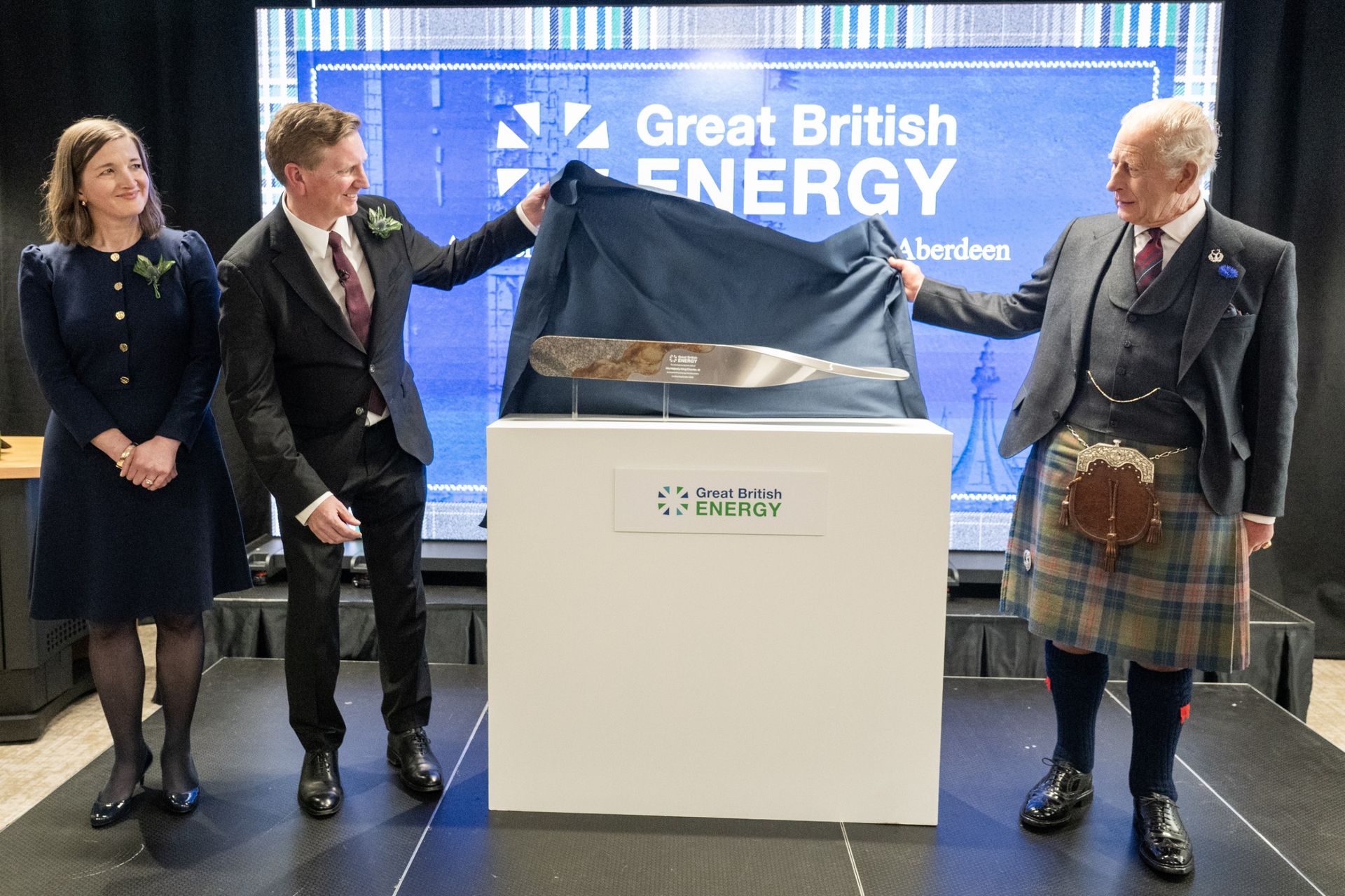 King Charles unveiling a plaque while wearing a kilt