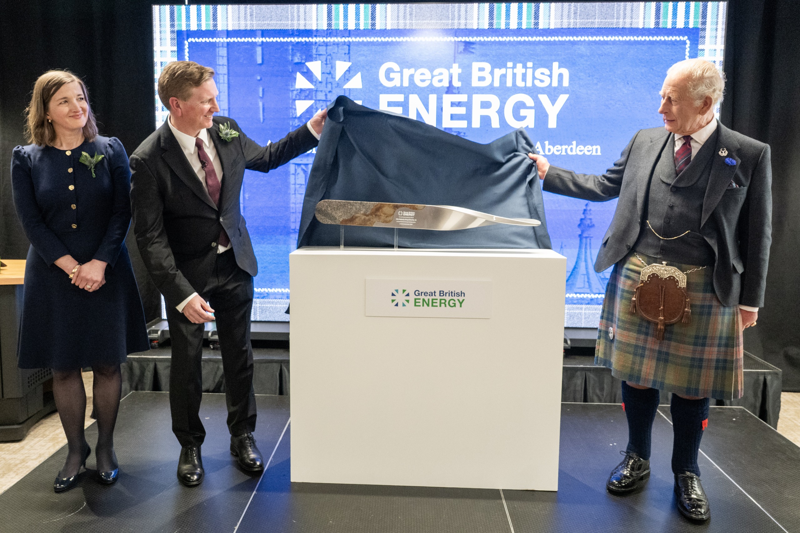 King Charles unveiling a plaque while wearing a kilt