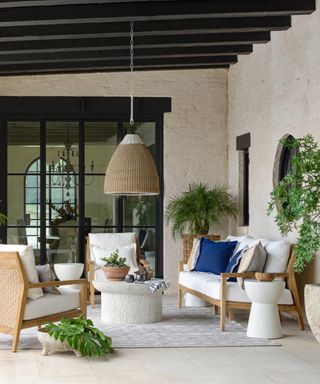 how to make your patio look expensive on a budget, undercover budget with white and wood furniture, white coffee table, pendant light,