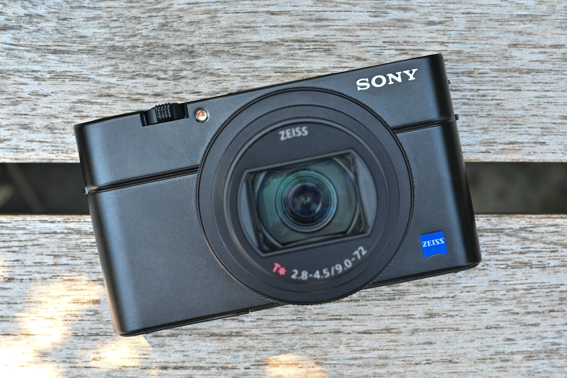 Et kompaktkamera av typen Sony RX100 VII på en trebenk.