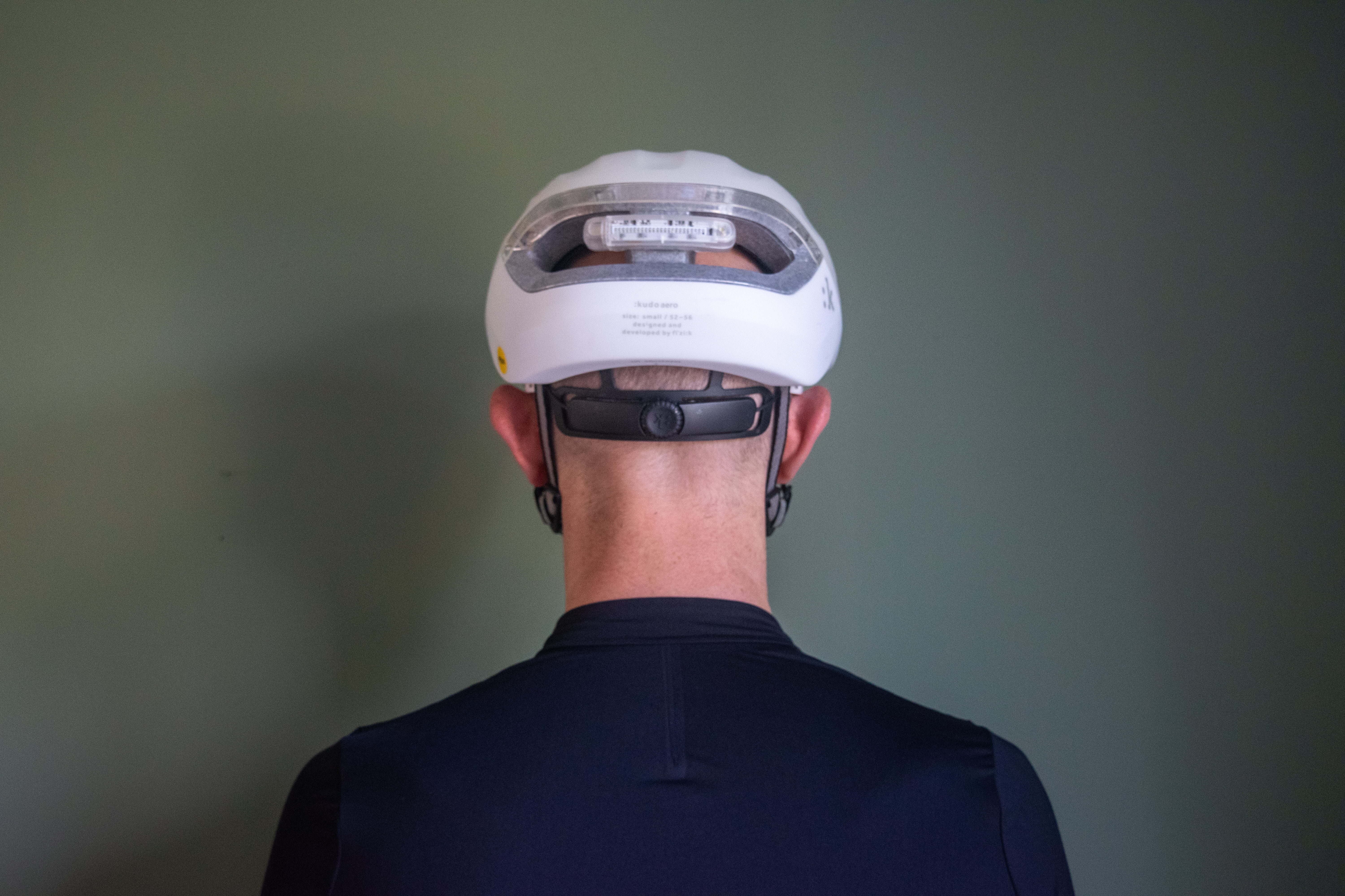 A man wearing a white fizik kudo aero helmet
