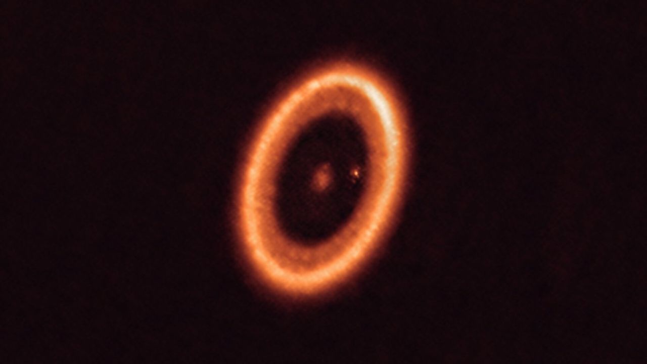 A solar system in the process of forming with a moon-forming disc around an exoplanet