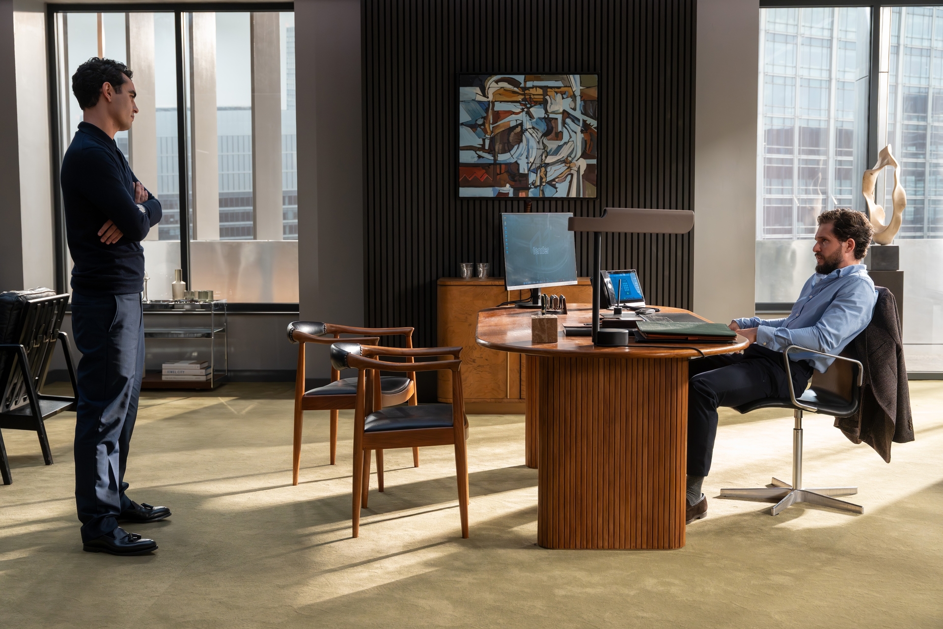 max minghella as whitney and kit harington as henry muck sitting at a desk in the tender office in industry season 4