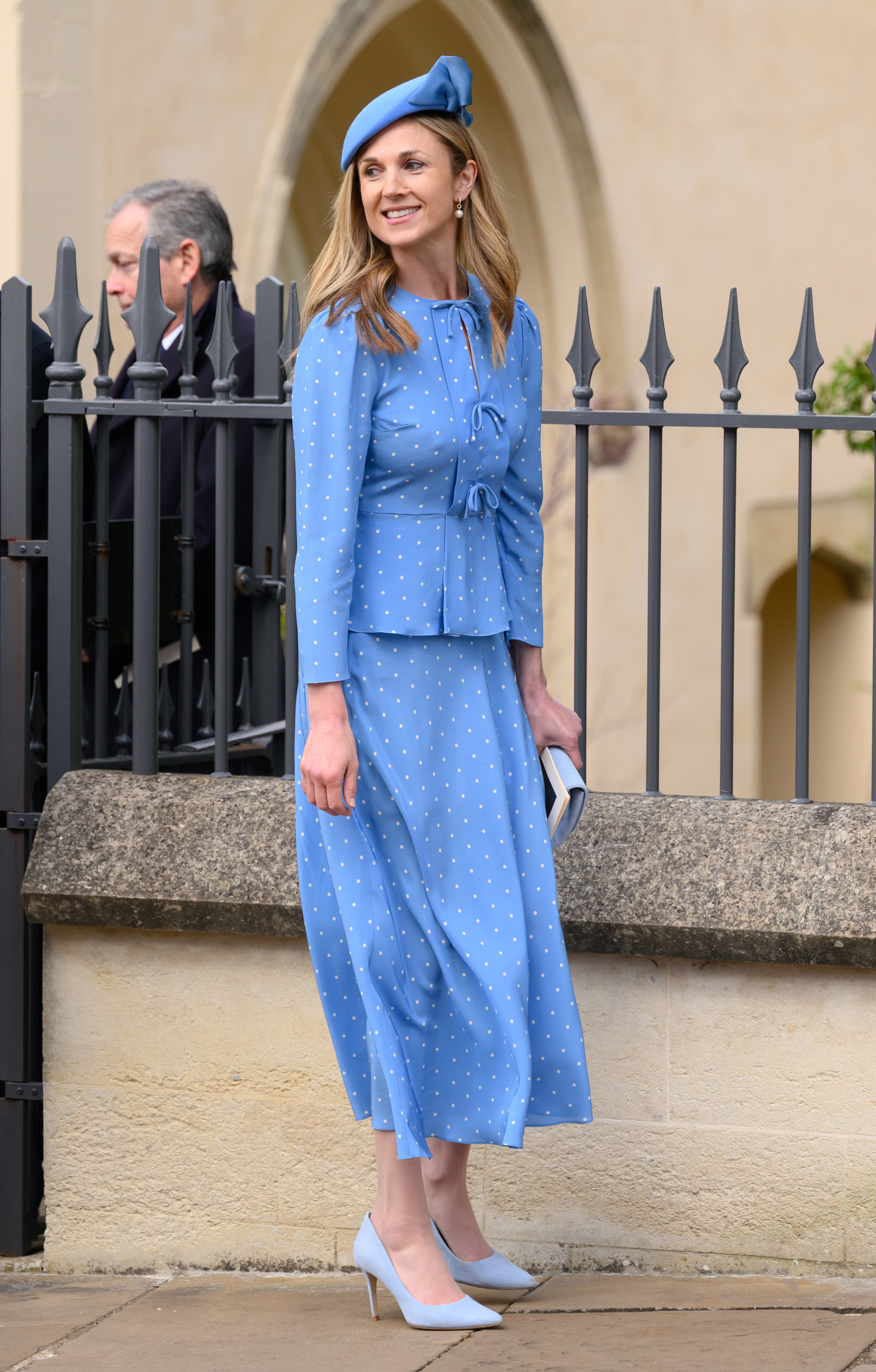 Harriet Sperling wearing a blue outfit and hat smiling outside St George's Chapel