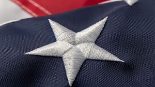 White embroidered star close-up on an American flag.