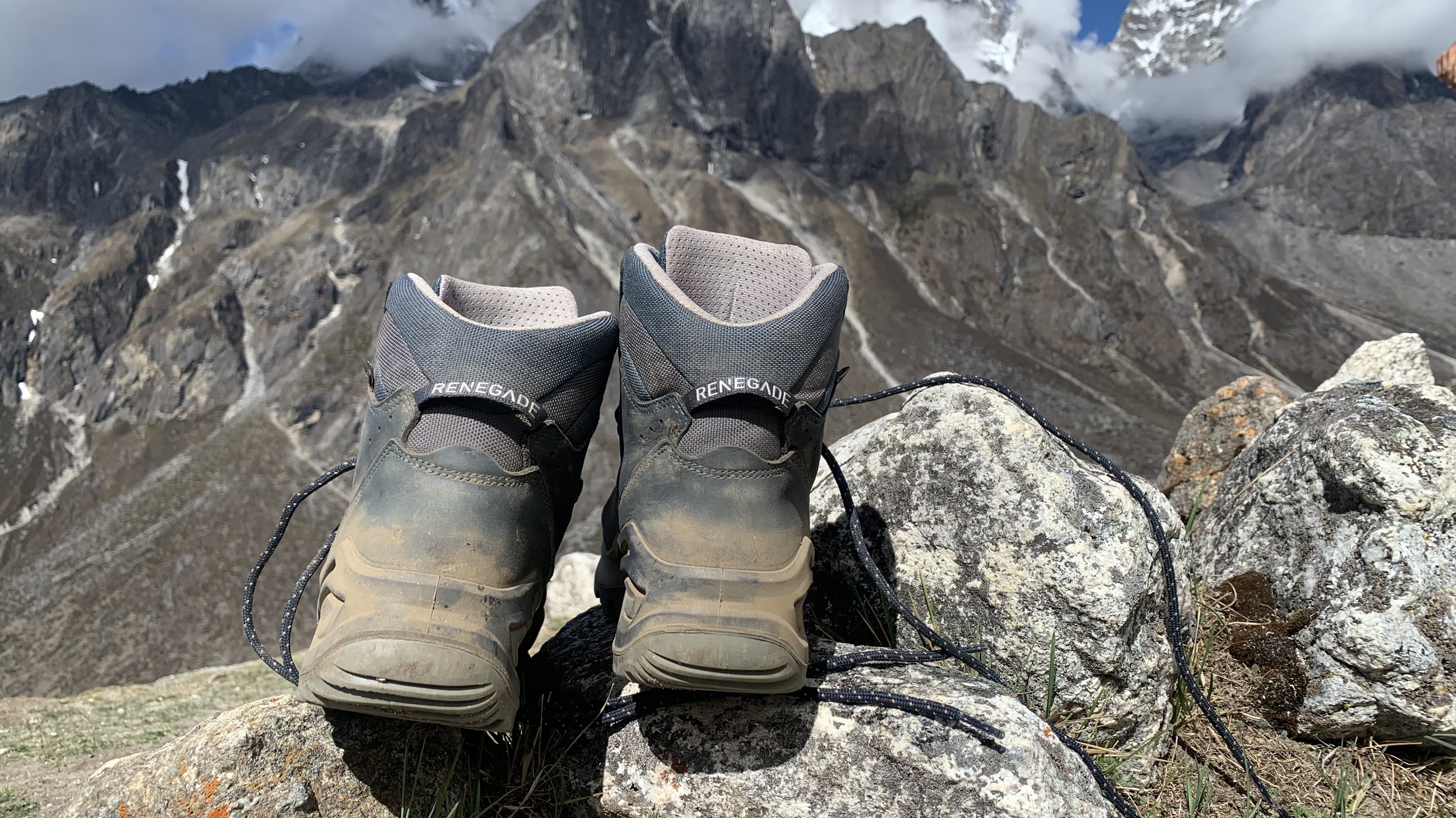 The Lowa Renegade EVO GTX Mid hiking boots on a rock with the Himalayas in the background