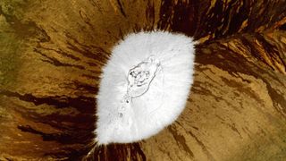 A satellite photo showing snow at the top of a mountains from above