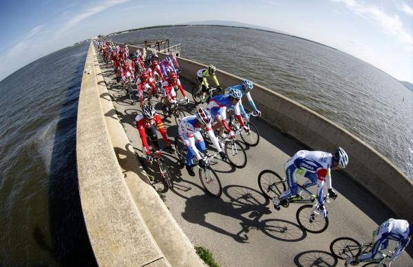 The peloton crosses a narrow bridge