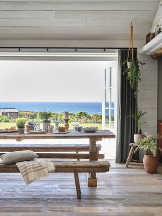 dining area with view of sea through open doors