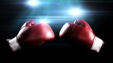 A pair of red boxing gloves against a black background with flashing lights.